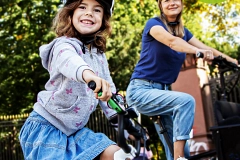 2026-06_Stadtradeln 2026 Kind und erwachsene Frau fahren Fahrräder, begleitet von einem "Stadtradeln"-Poster.
